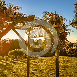 Close up of a wooden Chuppah with flowers and lace