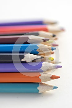 Close up of wooden colorful pencils, group of scattered crayons, isolated od white background