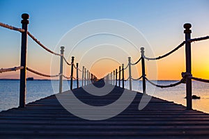 Close up ,a wooden dark bridge near the sea at bright orange sunset,backgound,texture,wallpaper, amazing romantic view, a path