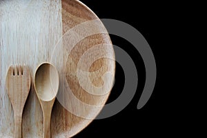 Close up wooden dish ,spoon and fork on black background