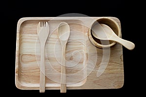 Close up wooden dish ,spoon and fork on black background
