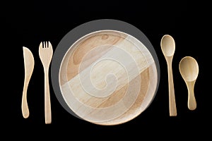 Close up wooden dish ,spoon,fork and knife on black background