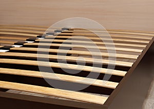 Close-up wooden elements of an arthopedic base of a double bed. Interior structure of furniture