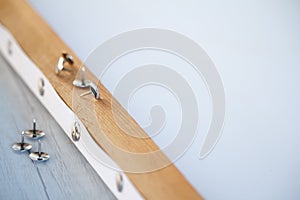 Close-up of a wooden frame on which white paper paper is stretched, buttons on the edge of the frame