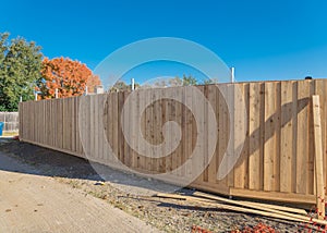 Close-up wooden garden fence installation at suburban residential back alley in autumn in Texas, USA