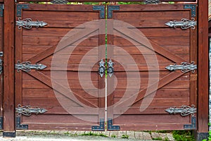 Close-up on a wooden gate with wrought iron hinged patterns