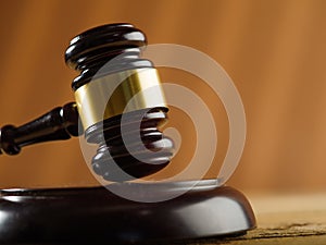 Close-up. Wooden gavel of the judge and in the background an open book on a dark beige background. Court and justice, Constitution