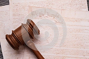 Close-up wooden gavel and old text.