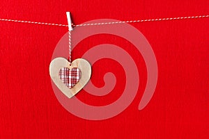 Close up of wooden heart simbol on red paper background