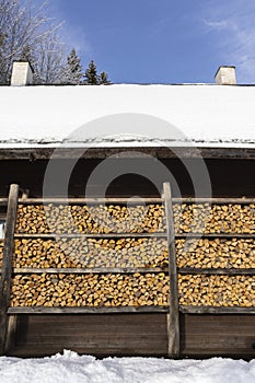 Close-up of wooden house walls with shelves holding firewood in Haanja, Estonia