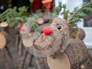 Close up wooden log versions of Rudolph red nosed reindeer Xmas holiday time