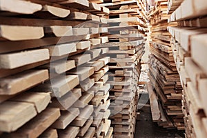 Close-up of wooden planks. Lumber warehouse. A photo with perspective. The background of the boards.