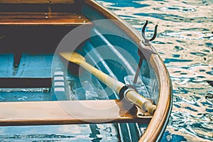 Close up of an wooden pleasure rowboat at the pier of a lake