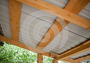 Close-up of wooden roof rafters with metal corrugated board, bottom view