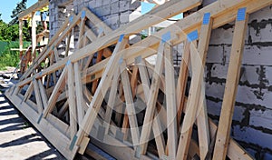 A close-up of a wooden roof truss components, webs, rafters, braces, struts ready for the roof framing during a house construction