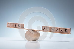 Risk And Reward Wooden Block On Seesaw photo