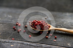 Pink peppercorn in wooden spoon studio shot