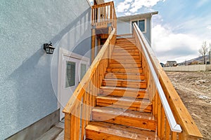 Close up of wooden stairway with handrails at home exterior against cloudy sky