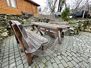 Close up of wooden table with benches in countryside. Log table and benches in empty village in cloudy weather.