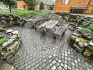 Close up of wooden table with benches in countryside. Log table and benches in empty village in cloudy weather.