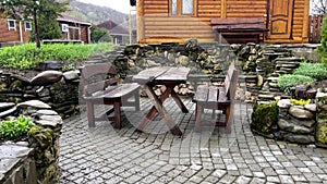 Close up of wooden table with benches in countryside. Log table and benches in empty village in cloudy weather.