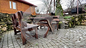 Close up of wooden table with benches in countryside. Log table and benches in empty village in cloudy weather.