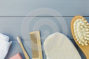Close up Wooden toothbrush, comb, towel, natural soap for skin and body care on gray background. Set for beauty, spa and bath.