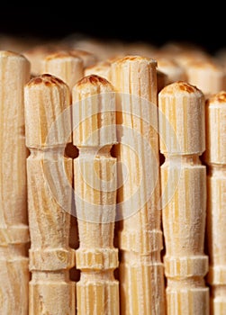 Close up of wooden toothpicks on a black background.