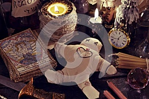 Close up of woodoo doll, knife, burning candles and magic objects