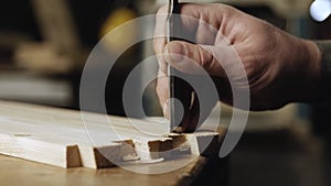 Close up. a woodworker cuts out a dovetail on a pine board with a chisel. dovetail joinery is done with a hand tool. woodworker