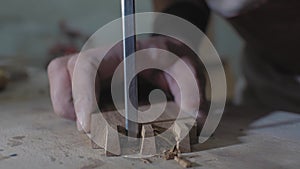 Close-up, a woodworker makes a dovetail on a wooden part with a chisel, on a workbench. a carpenter processes an oak blank. 4k. 4k