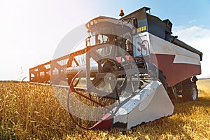 Close up The work of a combine harvester on a wheat field on a sunny day