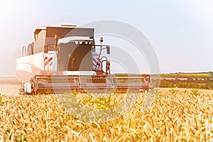 Close up The work of a combine harvester on a wheat field on a sunny day