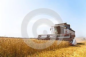 Close up The work of a combine harvester on a wheat field on a sunny day