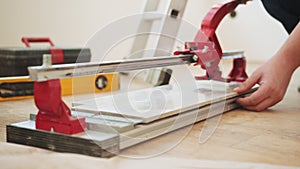 Close-up of a work tool using manual cutting equipment for laying, processing ceramic tiles. Industrial tiler builder