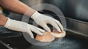 Close up. Worker Cooking Burger in Food Truck. Street Food Concept. Food in Town. Selling Snacks. Preparation of Sandwich.