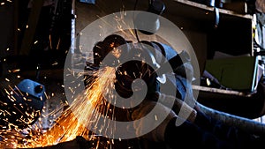 Close-up of worker cutting metal with grinder. Frame. Sparks while grinding iron. Circular cutting disc cuts of metal