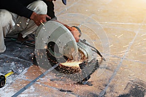 Close-up of worker cutting metal with grinder. Sparks while grin