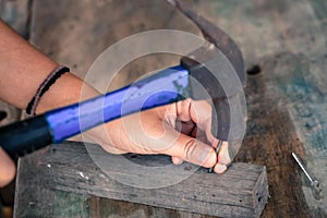 Close up worker hammering nail into wood, vintage style