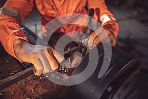 Close-up Worker handles metal at lathe Turner measures the dimensions of the metal workpiece with a caliper in uniform with safety