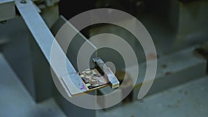 Close up of worker hands putting small metal tile for processing in industrial machine. Stock footage. Details of