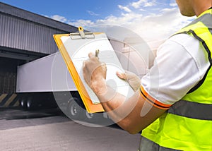 Close-Up Worker Holding Clipboard Loading Control Trailer truck. Truck Parked Loading at Dock Warehouse. Shipment Delivery Service