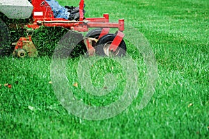 Close up on worker mowing the lawn