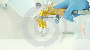 Close-up of worker's hand in blue rubber glove spraying urethane to finish or polish the board at furniture plant