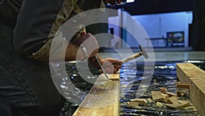 Close up of worker using tools for making holes in wooden beam. Media. Carpentry works for making decorations.