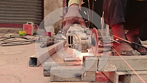 Close up of a workers hand using an angle grinder on metal with sparks flying