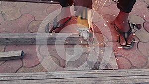 Close up of a workers hand using an angle grinder on metal with sparks flying