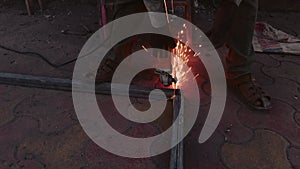 Close up of a workers hand using an angle grinder on metal with sparks flying