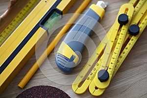 Workers set of instruments, box cutter, level, ruler equipment on wooden table
