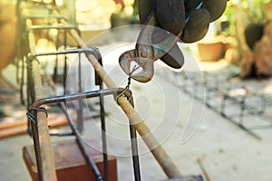 Close up of workers are using wire to tie steel bars